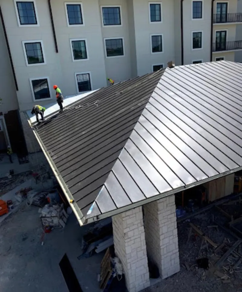 Crew installing standing seam metal roof panels on a commercial project in Indian River Estates